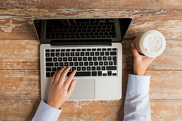 Image showing close up of female hands with laptop and coffee