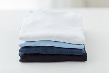 Image showing close up of ironed and folded t-shirts on table