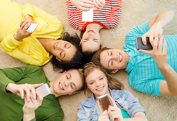 Image showing group of smiling people lying down on floor