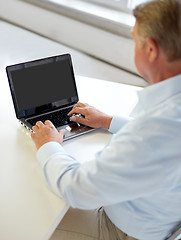 Image showing close up of senior man with laptop typing