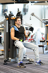 Image showing smiling man exercising on gym machine