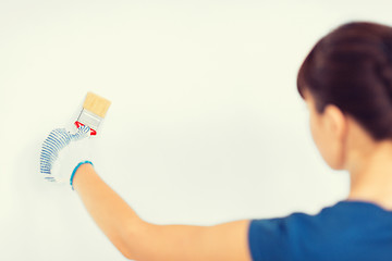 Image showing woman with paintbrush colouring the wall