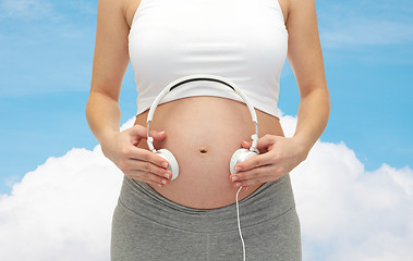 Image showing close up of pregnant woman and headphones on tummy