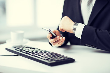 Image showing man hands with keyboard, smartphone and wristwatch