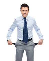 Image showing surprised businessman showing empty pockets