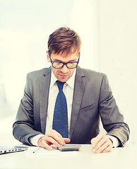 Image showing businessman with papers and calculator