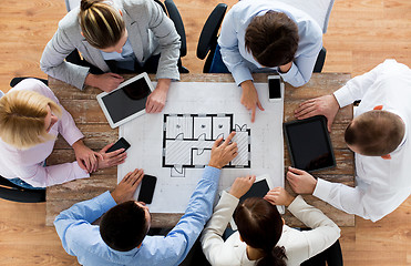 Image showing business team with blueprint and gadgets