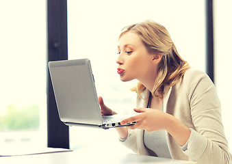 Image showing woman with computer kissing the screen