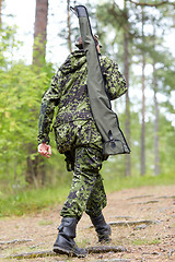 Image showing young soldier or hunter with gun in forest