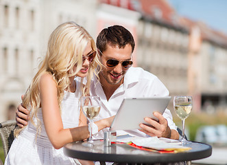 Image showing couple looking at tablet pc in cafe