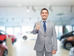 Image showing happy man over auto show or car salon background
