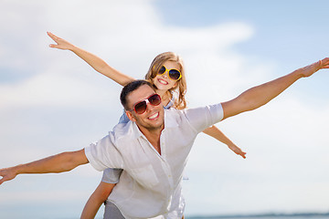 Image showing happy father and child in sunglasses over blue sky