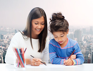 Image showing happy mother and daughter drawing with pencils