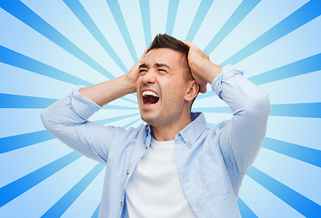 Image showing unhappy man with closed eyes touching his forehead