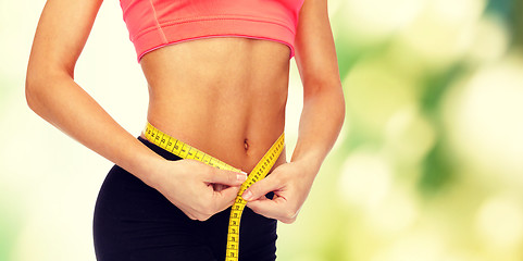 Image showing close up of female hands measuring waist