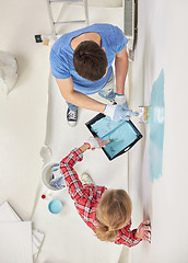 Image showing close up of couple painting wall at home