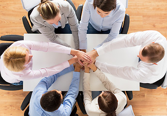 Image showing close up of business team with hands on top