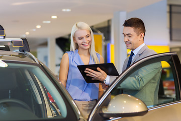 Image showing happy woman with car dealer in auto show or salon