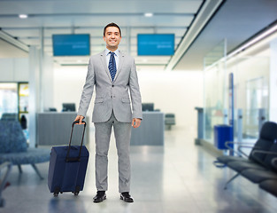 Image showing happy businessman in suit with travel bag