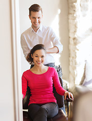 Image showing happy woman with stylist making hairdo at salon