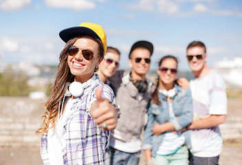 Image showing teenage girl with headphones and friends outside