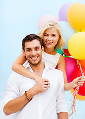 Image showing couple with colorful balloons at seaside