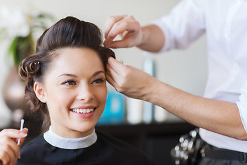 Image showing happy woman with stylist making hairdo at salon