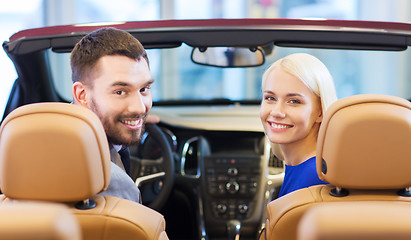 Image showing happy couple sitting in car at auto show or salon