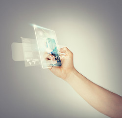 Image showing man hand with smartphone and virtual screen