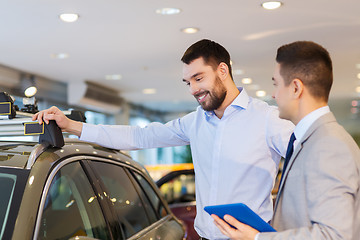 Image showing happy man with car dealer in auto show or salon