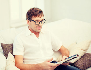 Image showing man with magazine at home