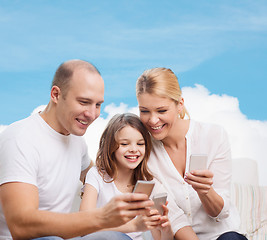 Image showing happy family with smartphones