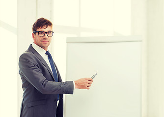 Image showing businessman pointing to flip board in office