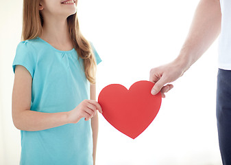 Image showing close up of girl and male hand holding red heart