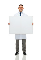 Image showing smiling male doctor holding white blank board