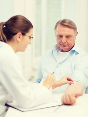 Image showing female doctor doing injection to old man