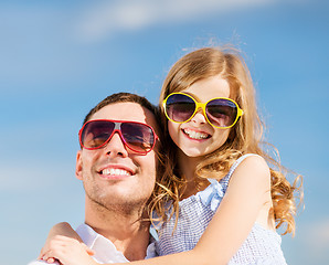 Image showing happy father and child in sunglasses over blue sky