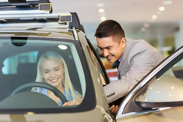 Image showing happy woman with car dealer in auto show or salon