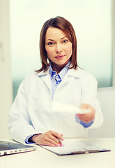 Image showing busy doctor with laptop computer and clipboard