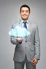 Image showing happy businessman showing virtual cloud projection