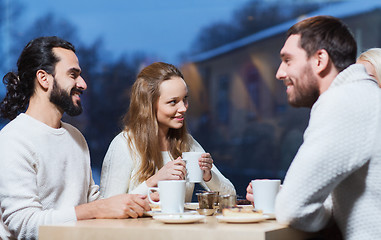 Image showing happy friends meeting and drinking tea or coffee