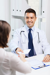 Image showing smiling doctor and young woman meeting at hospital