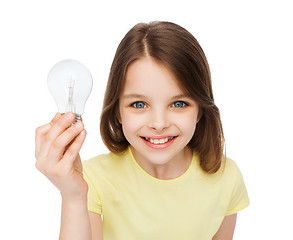 Image showing smiling little girl holding light bulb