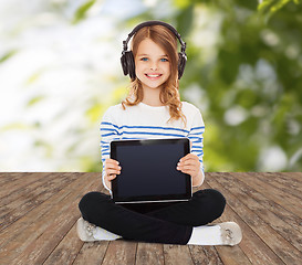 Image showing happy girl with headphones showing tablet pc