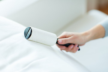 Image showing close up of woman hand with sticky roller cleaning