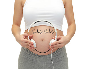 Image showing close up of pregnant woman and headphones on tummy