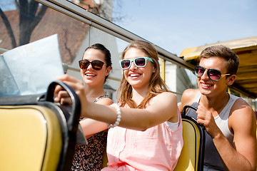 Image showing group of smiling friends traveling by tour bus