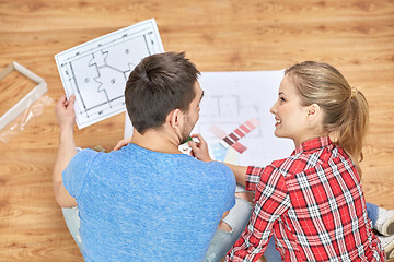 Image showing happy couple with blueprint and color samples