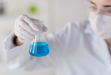 Image showing close up of woman with flask making test in lab