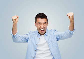 Image showing happy laughing man with raised hands